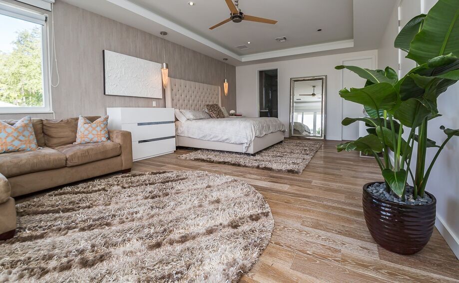 Modernes Hauptschlafzimmer mit beiger Wandfarbe und hellem Holzboden in Miami