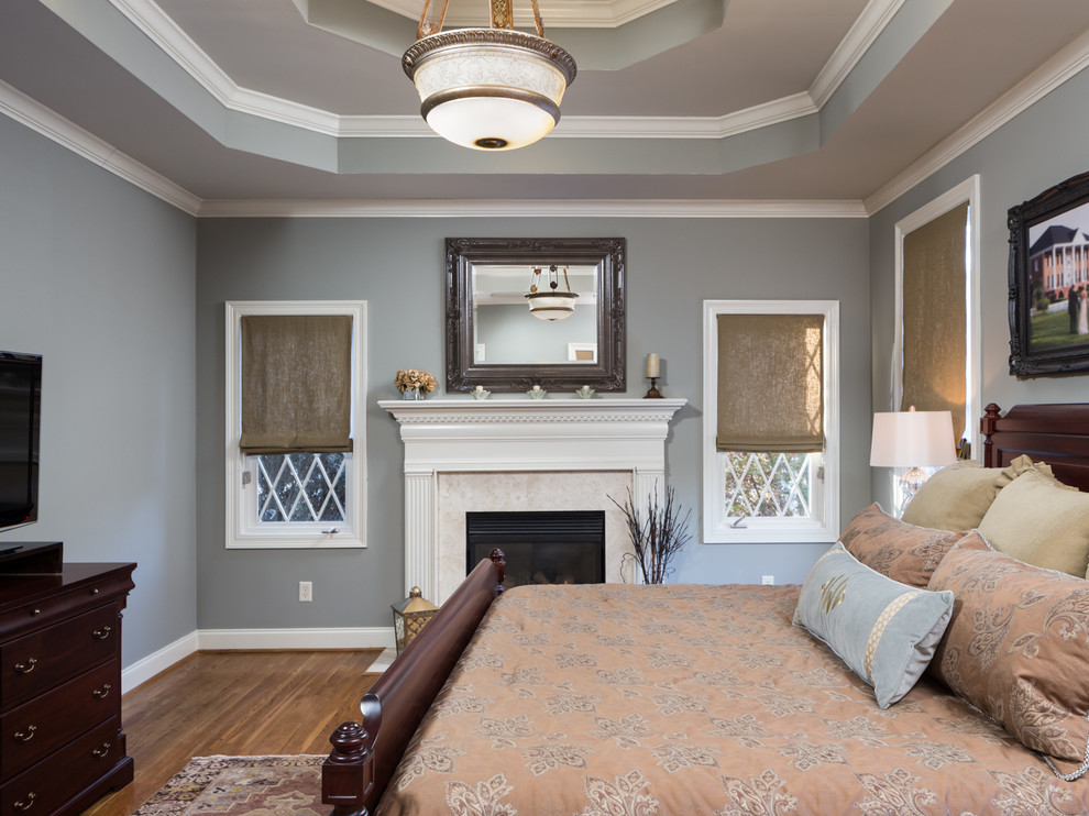 Источник вдохновения для домашнего уюта: хозяйская спальня среднего размера в классическом стиле с серыми стенами, паркетным полом среднего тона, стандартным камином и фасадом камина из дерева
