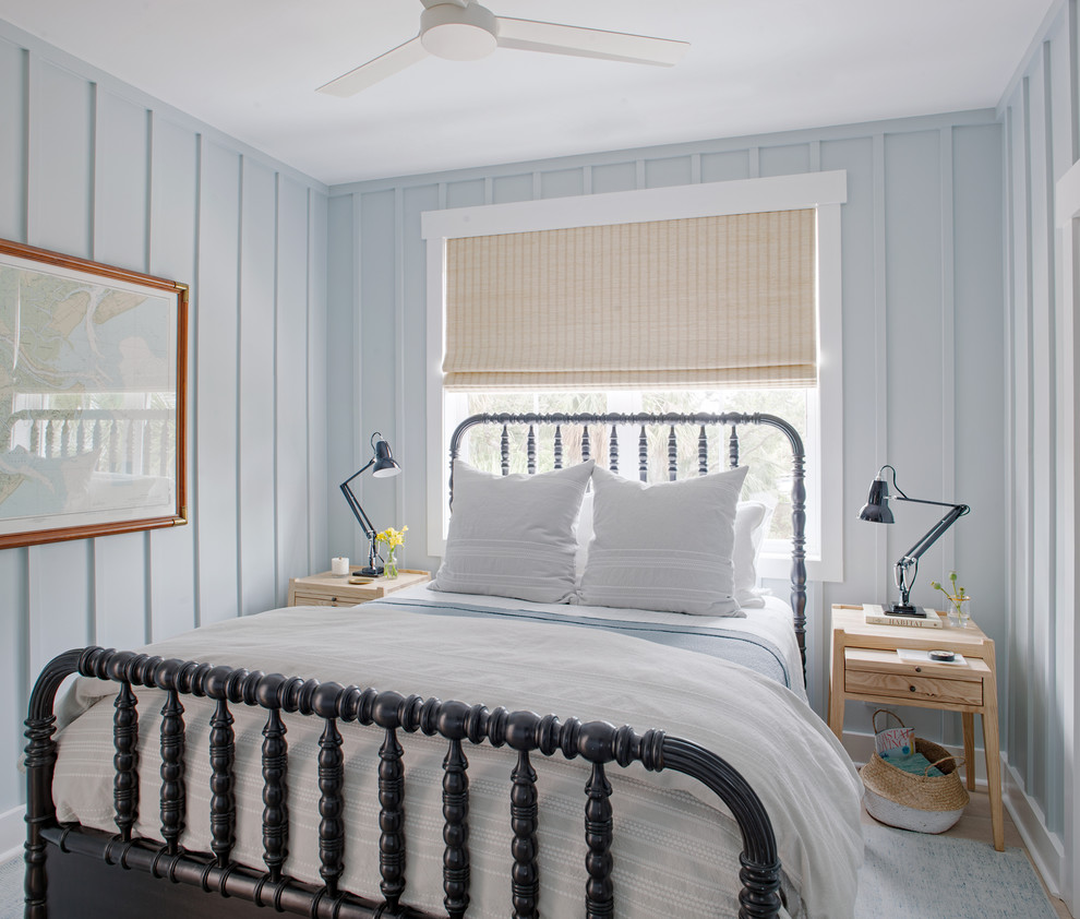Diseño de habitación de invitados costera pequeña sin chimenea con paredes azules y suelo de madera clara