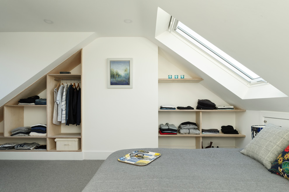 Modelo de dormitorio actual pequeño con paredes blancas, moqueta, suelo gris y techo inclinado