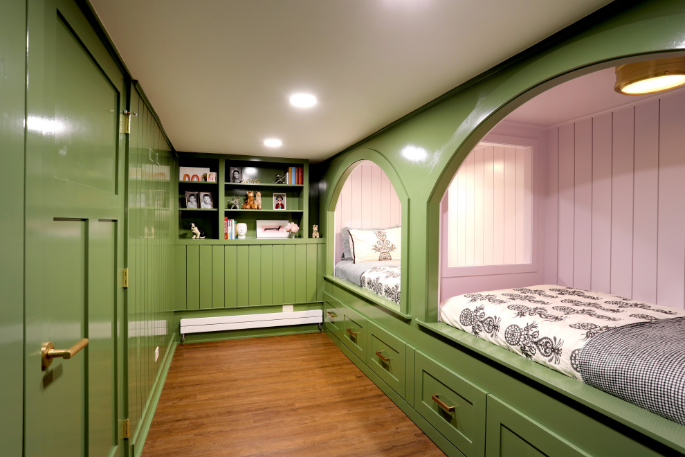 Modelo de dormitorio clásico renovado con paredes verdes, suelo laminado, suelo marrón y machihembrado