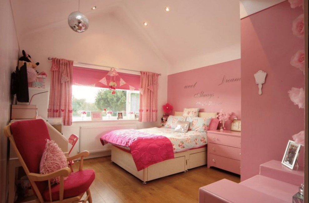 На фото: большая гостевая спальня (комната для гостей) в стиле модернизм с розовыми стенами, полом из ламината и бежевым полом с