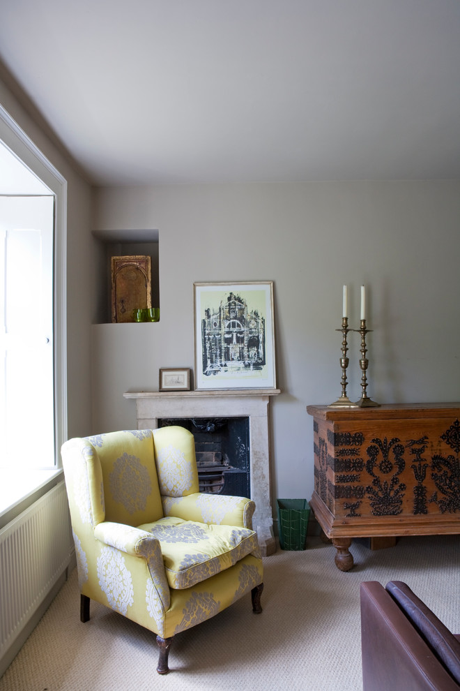 Cette photo montre une chambre avec moquette nature avec un mur gris, une cheminée standard, un manteau de cheminée en pierre et un sol beige.