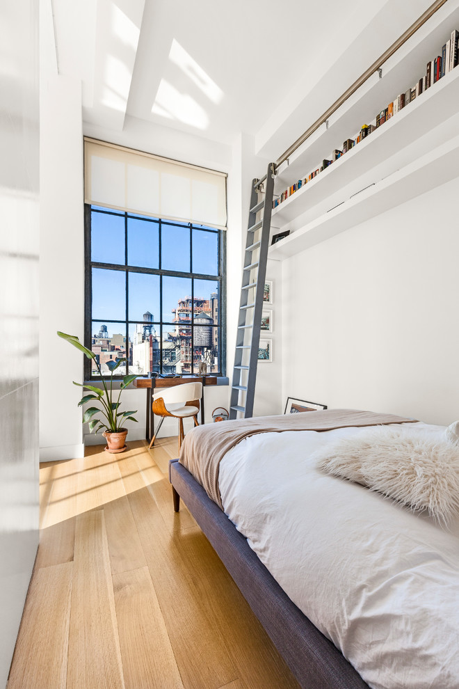 Modernes Hauptschlafzimmer mit weißer Wandfarbe und hellem Holzboden in New York