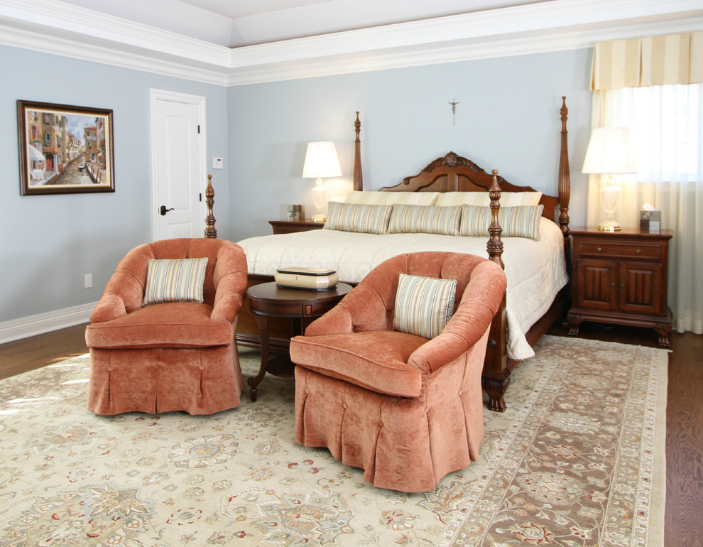 Foto de dormitorio principal tradicional de tamaño medio sin chimenea con paredes azules, suelo de madera oscura y suelo marrón