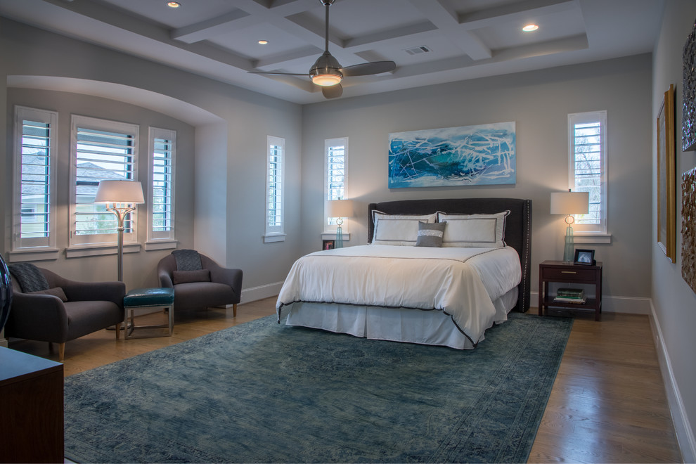 This is an example of a large traditional master and grey and brown bedroom in Houston with grey walls, medium hardwood flooring, no fireplace, brown floors and feature lighting.