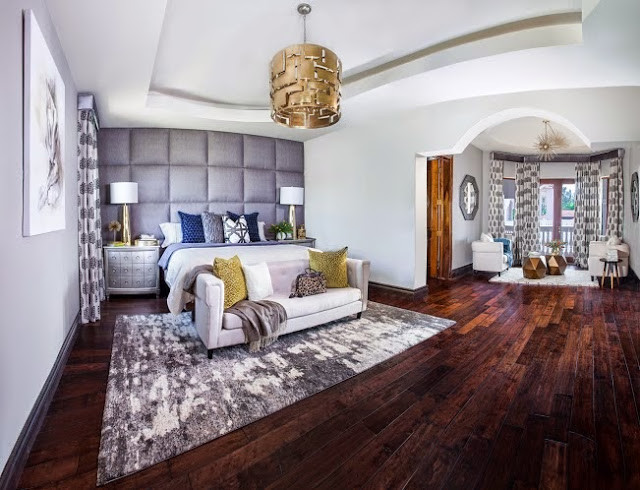Foto de dormitorio principal actual grande con paredes grises y suelo de madera en tonos medios