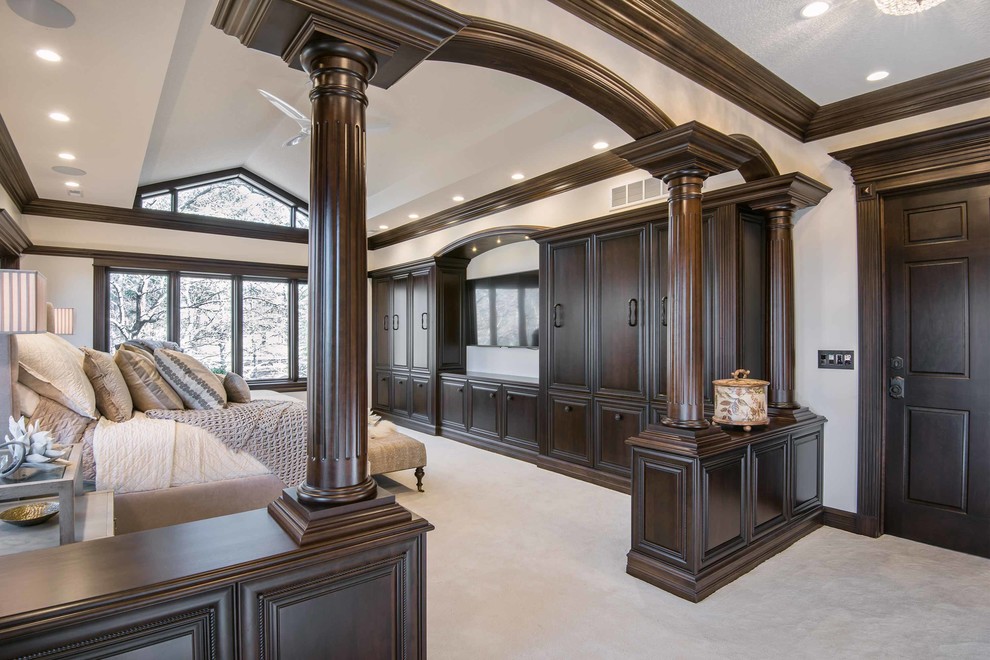На фото: огромная хозяйская спальня в классическом стиле с бежевыми стенами и ковровым покрытием с