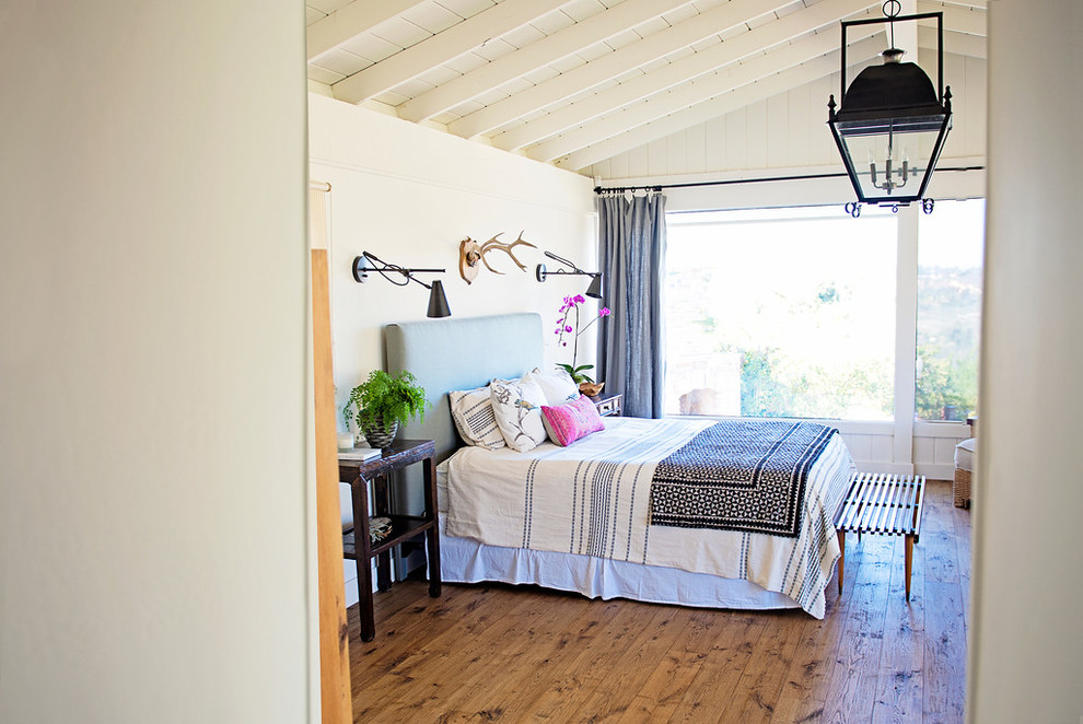 Ejemplo de dormitorio principal costero de tamaño medio sin chimenea con paredes beige y suelo de madera clara