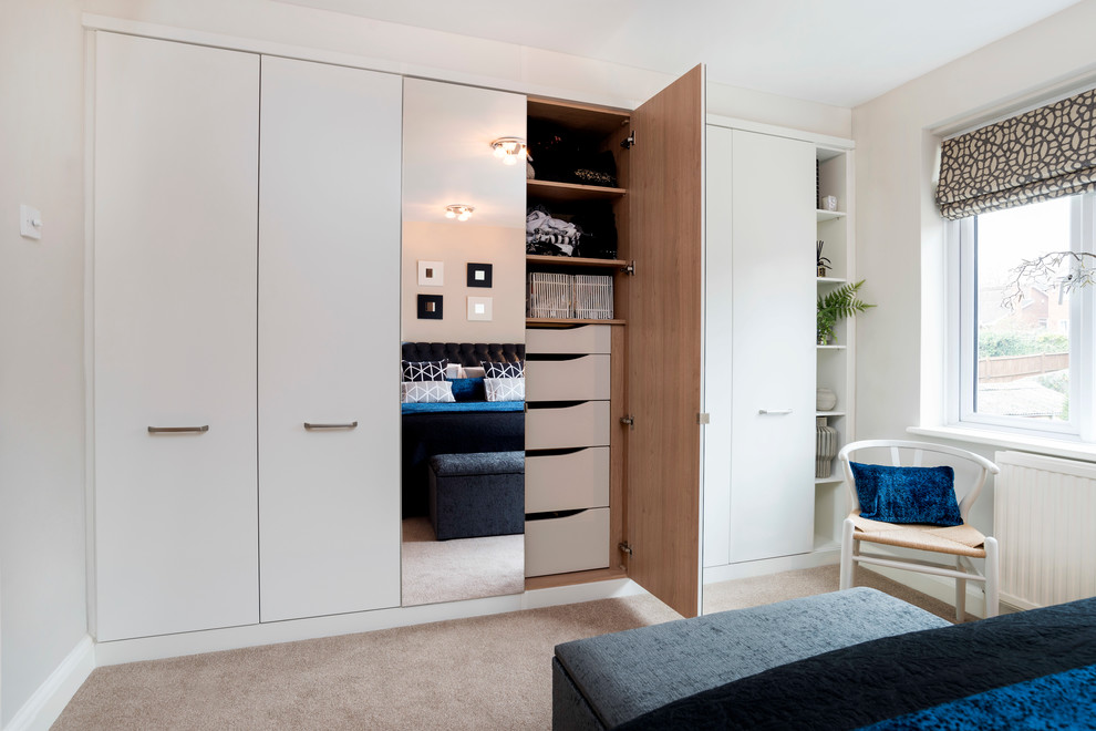 Example of a mid-sized danish master carpeted bedroom design in London with white walls