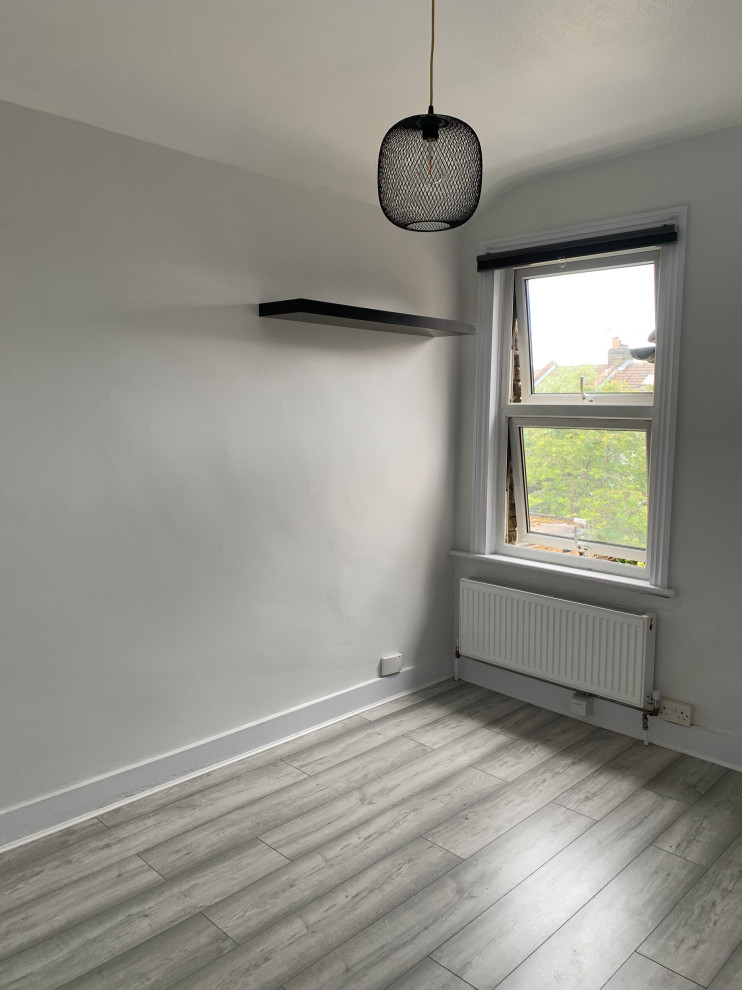 Kleines Modernes Gästezimmer mit grauer Wandfarbe, Laminat und grauem Boden in Surrey