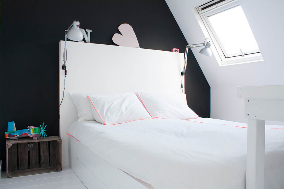 На фото: спальня в стиле фьюжн с черными стенами, деревянным полом, белым полом и акцентной стеной с