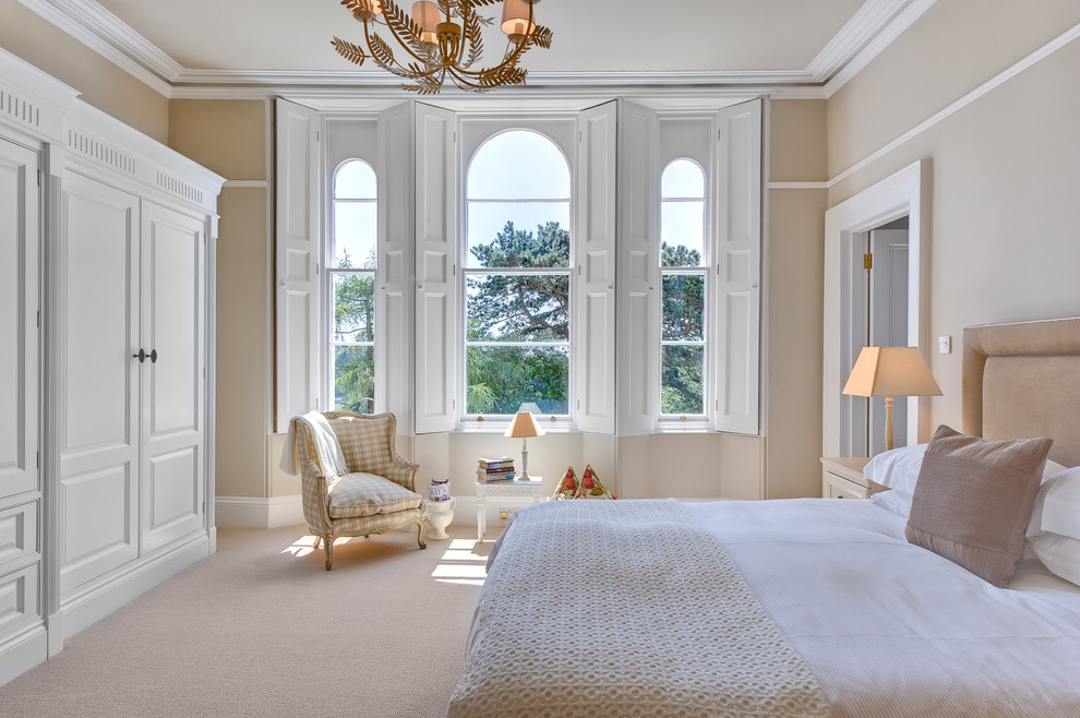 Inspiration for a large classic master bedroom in Devon with beige walls and carpet.