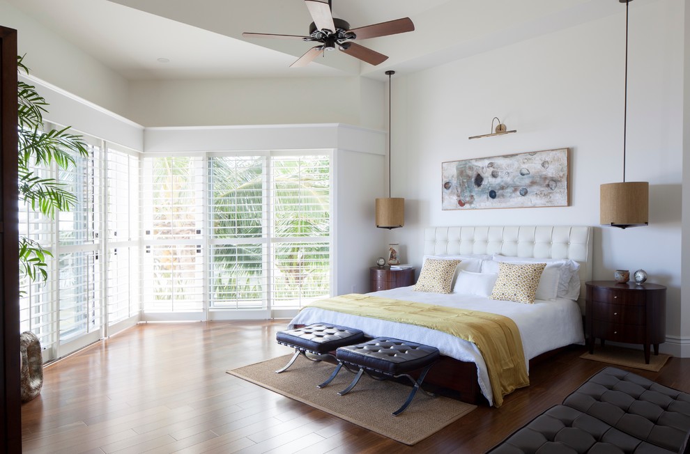 Immagine di una camera da letto tropicale con pareti bianche e parquet scuro