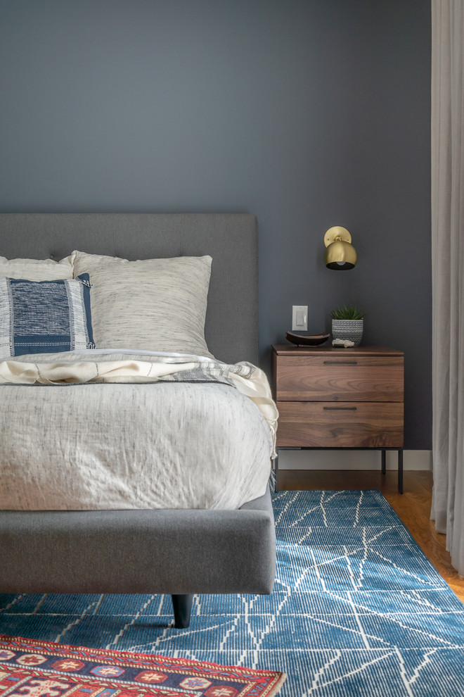 Foto de dormitorio principal contemporáneo grande sin chimenea con paredes azules y suelo de madera en tonos medios