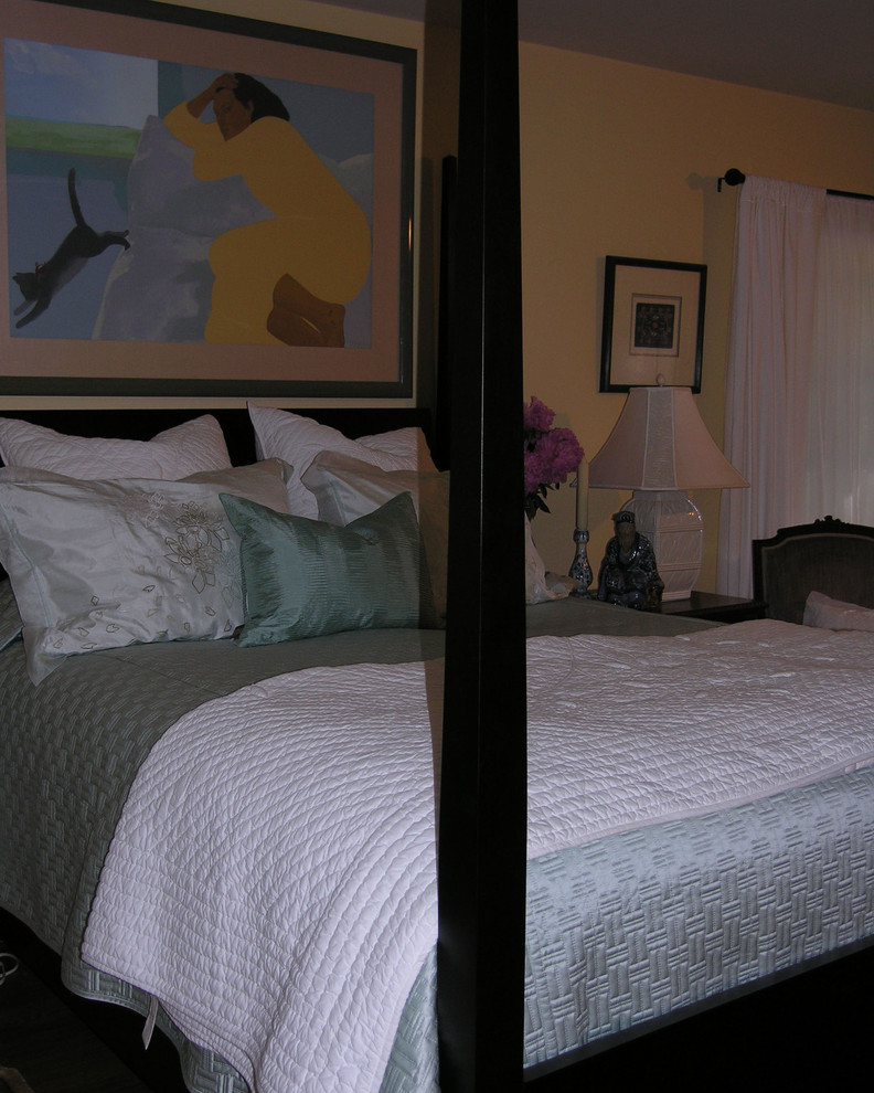 Imagen de dormitorio principal clásico con paredes amarillas y suelo de travertino