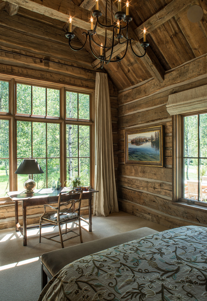 На фото: хозяйская спальня среднего размера в стиле рустика с коричневыми стенами и ковровым покрытием