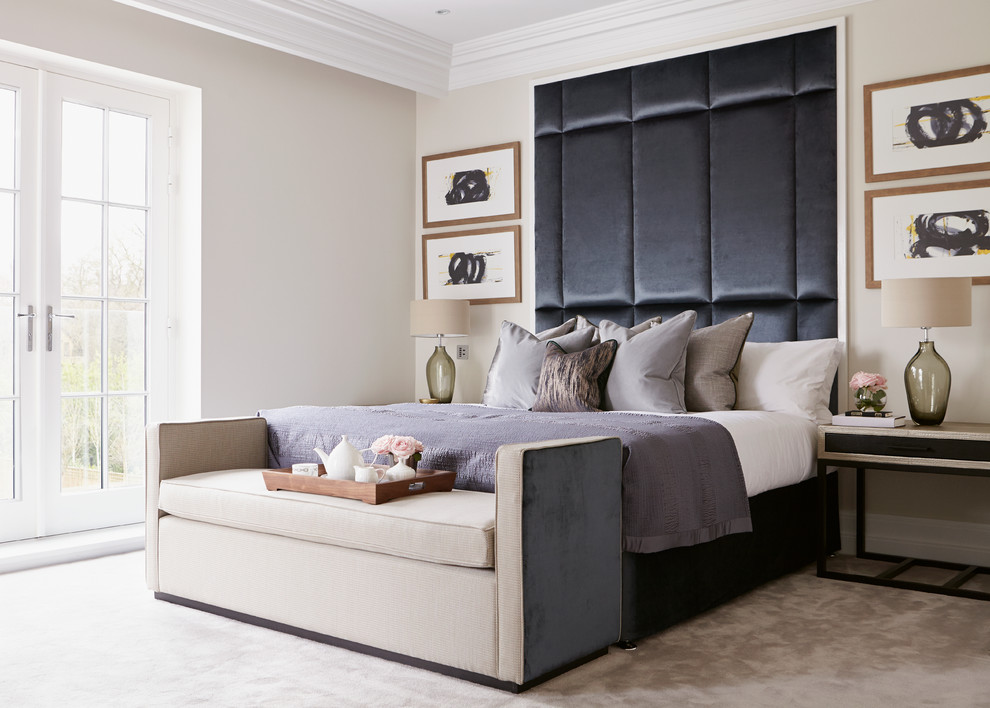 This is an example of a contemporary bedroom in London with beige walls and carpet.