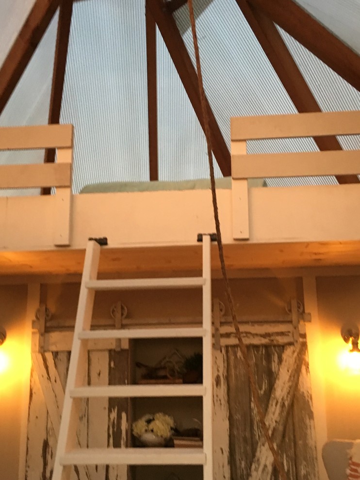 Modelo de dormitorio tipo loft de estilo de casa de campo pequeño con suelo de madera clara