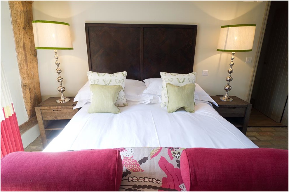Foto de habitación de invitados campestre de tamaño medio con paredes beige y suelo de ladrillo