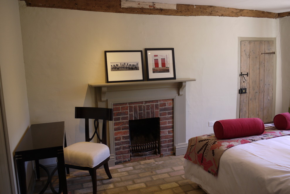 На фото: гостевая спальня среднего размера, (комната для гостей) в стиле кантри с бежевыми стенами и кирпичным полом с