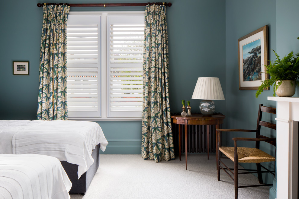 ロンドンにあるトラディショナルスタイルのおしゃれな客用寝室 (青い壁、カーペット敷き、標準型暖炉、白い床) のレイアウト