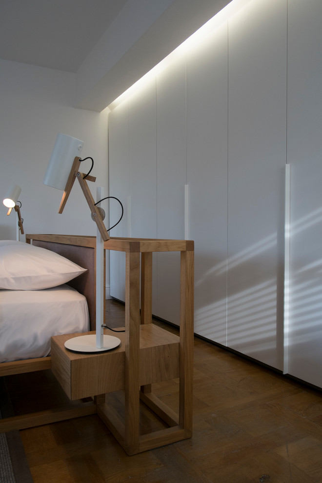 Idee per una camera da letto stile loft contemporanea di medie dimensioni con pareti bianche e pavimento in legno massello medio