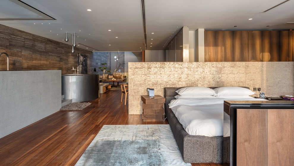 Идея дизайна: хозяйская спальня в современном стиле с коричневыми стенами и паркетным полом среднего тона