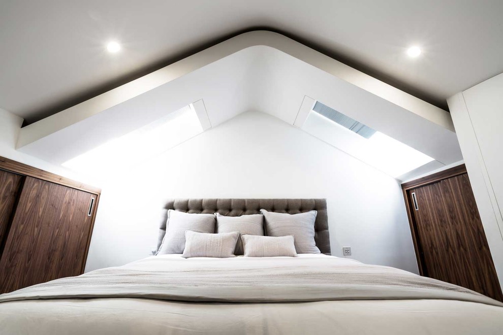 Medium sized contemporary mezzanine bedroom in London with white walls, dark hardwood flooring and no fireplace.