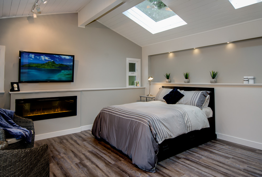 Exemple d'une chambre d'amis chic de taille moyenne avec un mur beige, un sol en vinyl et une cheminée standard.