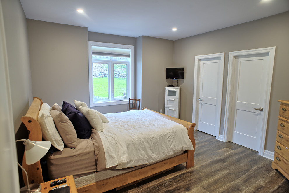 Cette photo montre une chambre parentale moderne de taille moyenne avec un mur beige, un sol en bois brun, aucune cheminée et un sol marron.