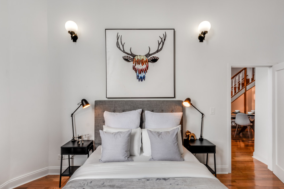 Imagen de dormitorio principal clásico renovado pequeño con paredes blancas, suelo de madera clara y suelo beige