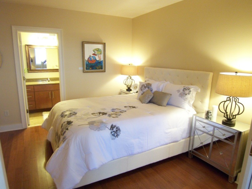 Ejemplo de dormitorio principal clásico pequeño sin chimenea con paredes beige, suelo de madera clara y suelo beige