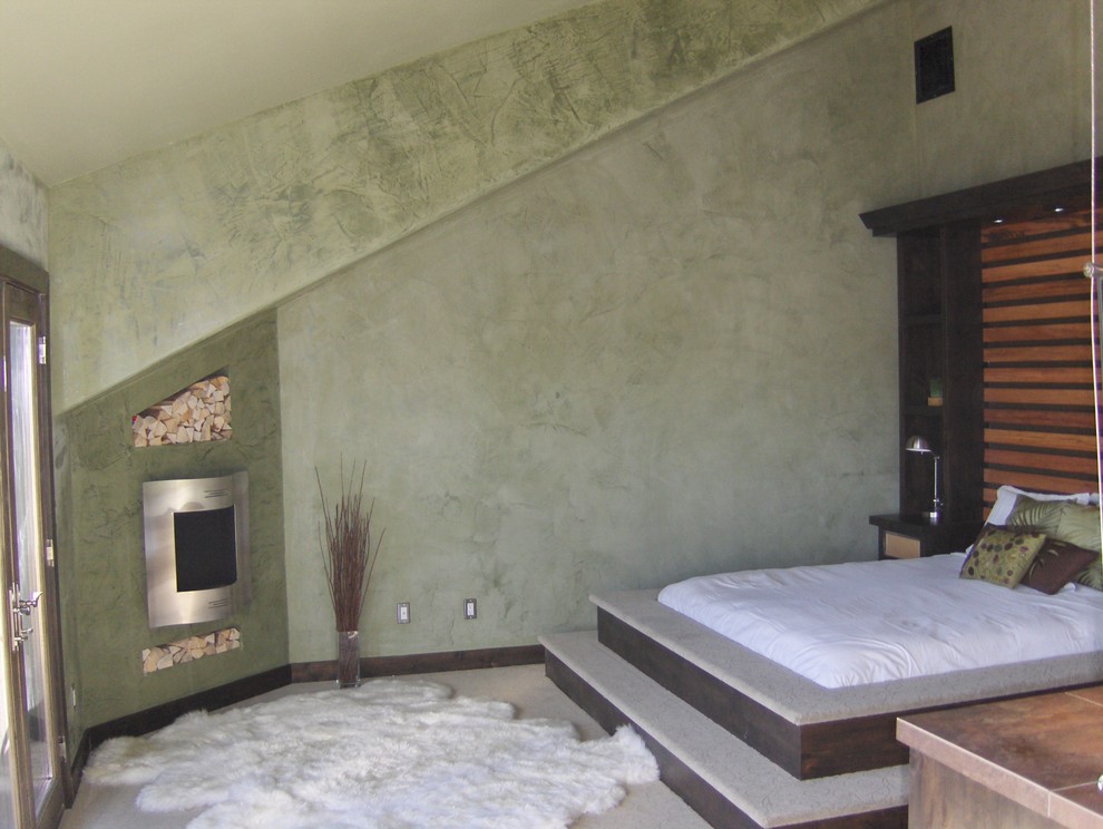 На фото: гостевая спальня среднего размера, (комната для гостей) в средиземноморском стиле с зелеными стенами, ковровым покрытием, стандартным камином, фасадом камина из металла и зеленым полом с