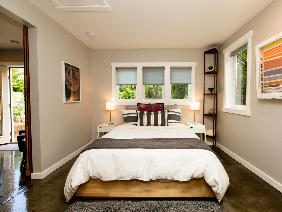 Modelo de dormitorio principal rústico de tamaño medio sin chimenea con paredes grises, suelo de cemento y suelo marrón