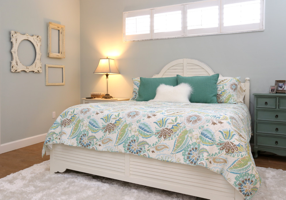 Foto de dormitorio principal costero de tamaño medio con paredes azules, suelo de baldosas de porcelana y suelo marrón