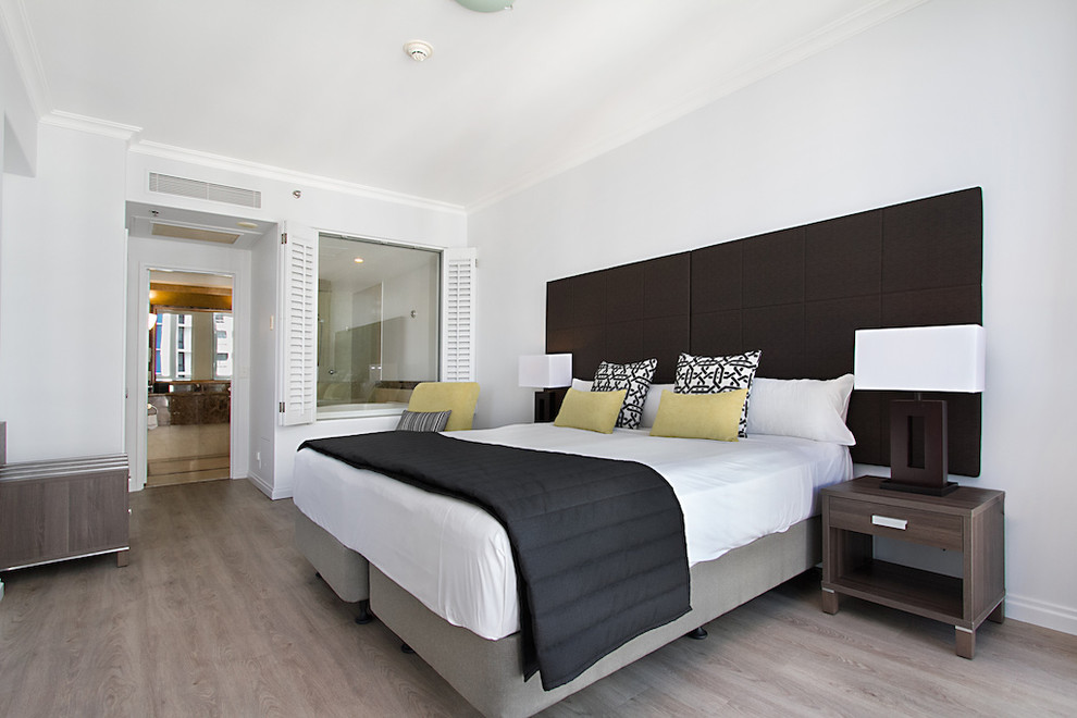Esempio di una piccola camera degli ospiti minimalista con pareti bianche, pavimento in vinile e nessun camino