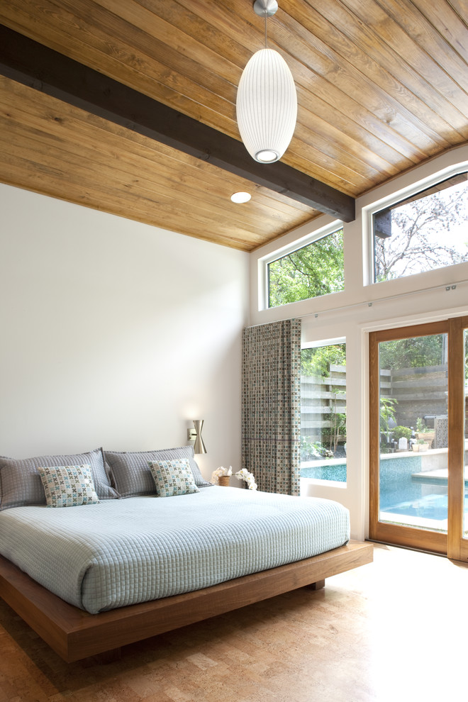 Mid-Century Schlafzimmer mit weißer Wandfarbe und braunem Holzboden in Austin