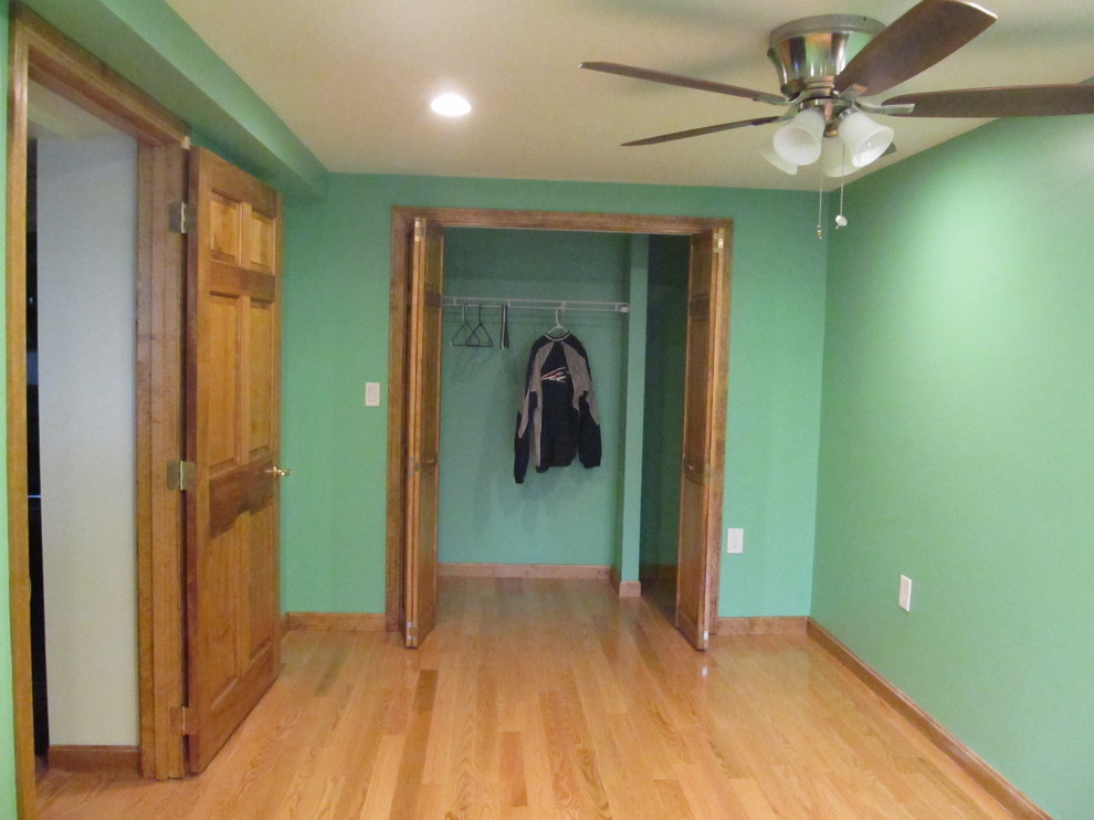 Ejemplo de habitación de invitados clásica de tamaño medio sin chimenea con paredes verdes y suelo de madera en tonos medios