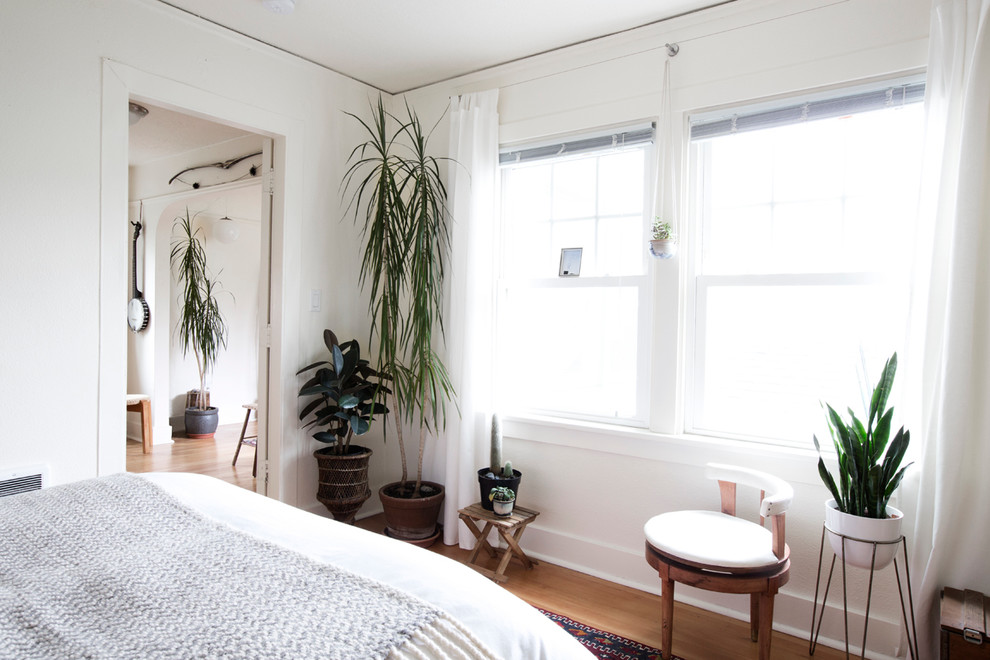 Idée de décoration pour une chambre vintage avec un mur blanc et un sol en bois brun.