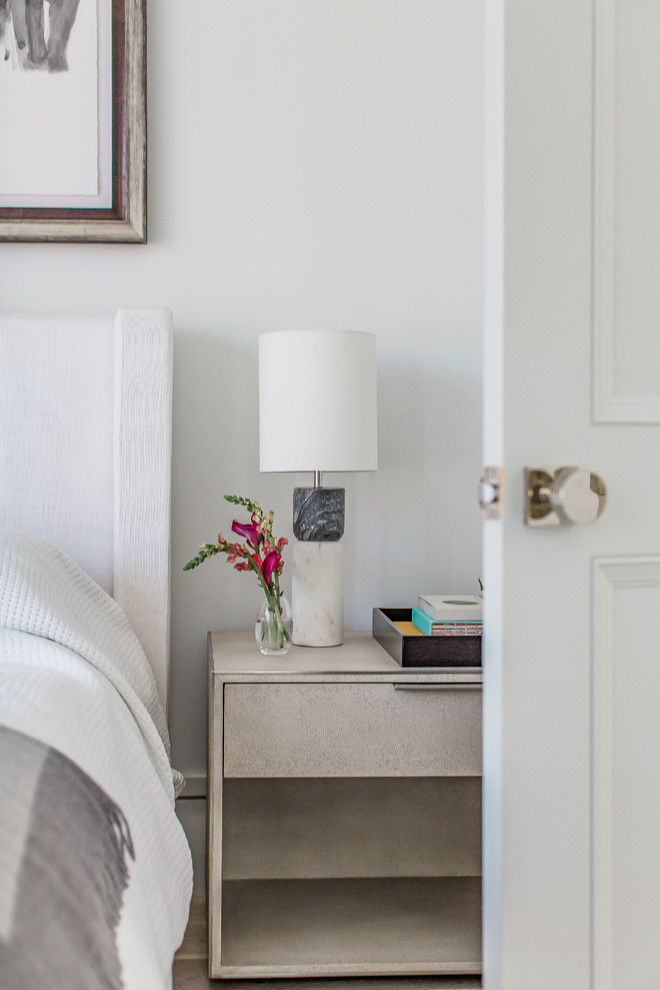 Ejemplo de dormitorio moderno de tamaño medio sin chimenea con paredes blancas, suelo de madera clara y suelo beige