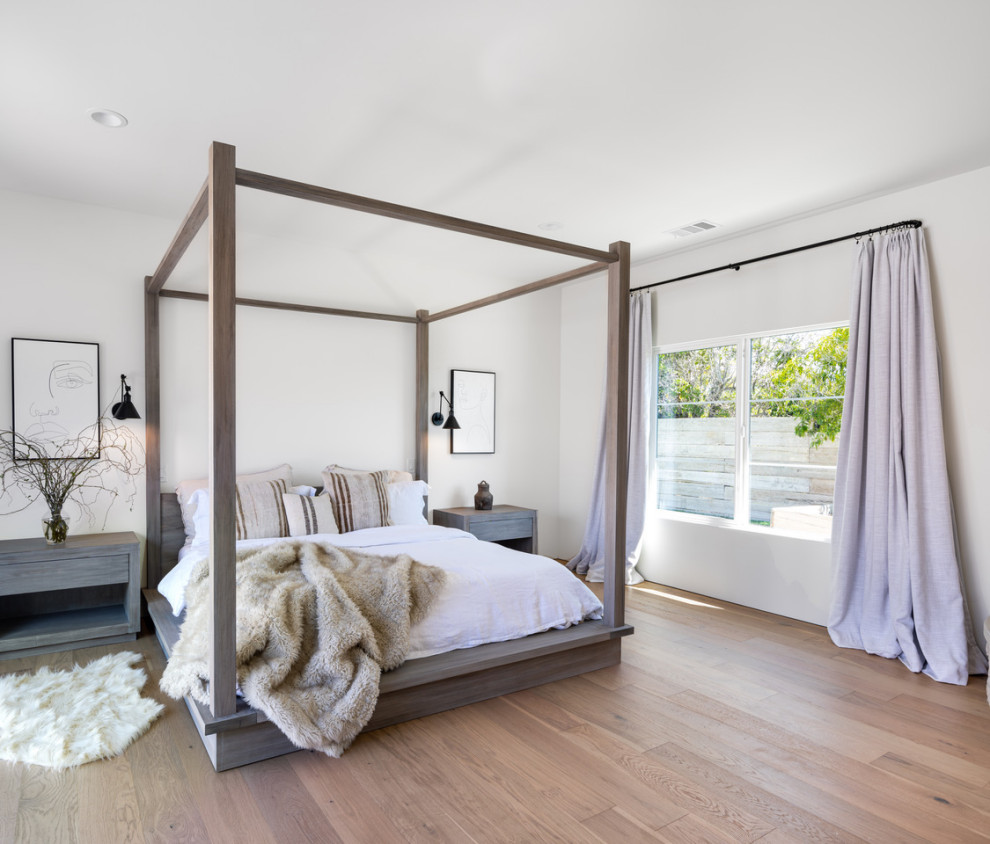 Design ideas for a mediterranean master bedroom in San Diego with white walls and light hardwood flooring.