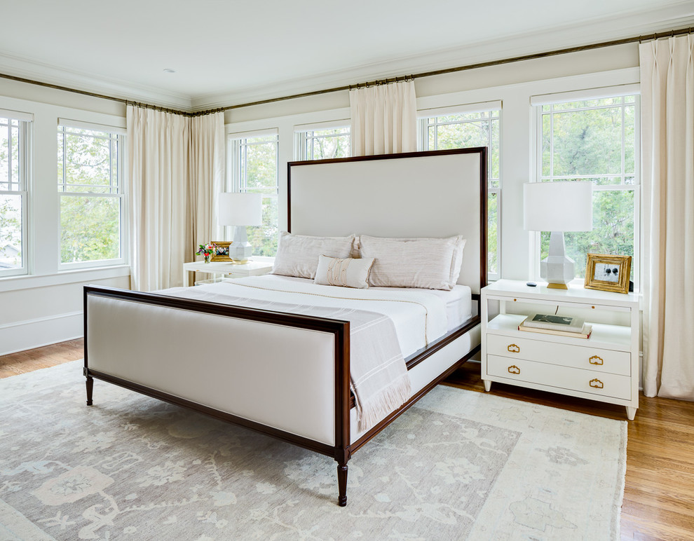 Ejemplo de dormitorio principal tradicional grande sin chimenea con paredes blancas y suelo de madera en tonos medios