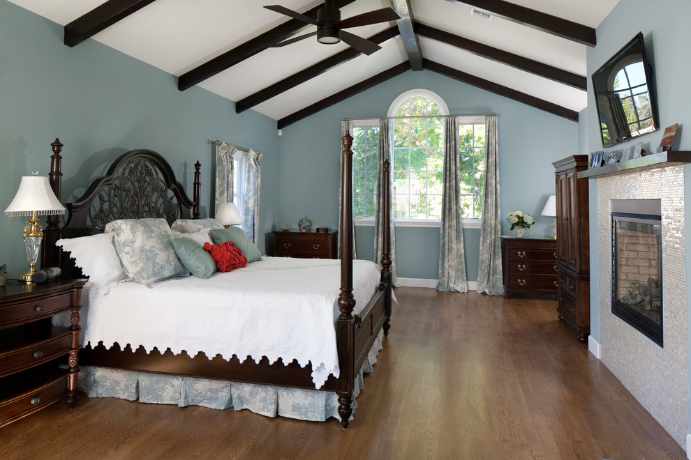 Design ideas for a medium sized classic master bedroom in Los Angeles with blue walls, medium hardwood flooring, a standard fireplace and a tiled fireplace surround.
