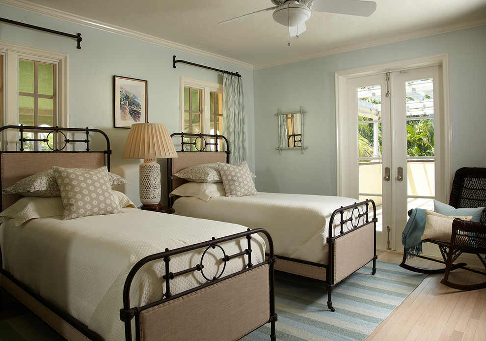 Diseño de habitación de invitados costera con paredes azules y suelo de madera clara
