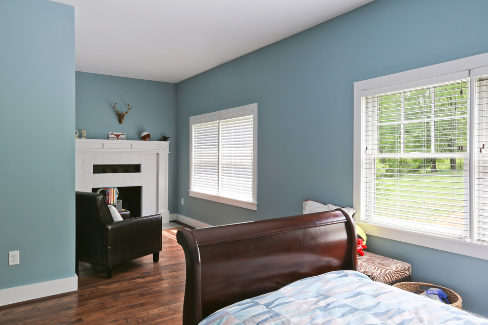 Пример оригинального дизайна: большая гостевая спальня (комната для гостей) в стиле кантри с синими стенами, темным паркетным полом, стандартным камином, фасадом камина из плитки и коричневым полом