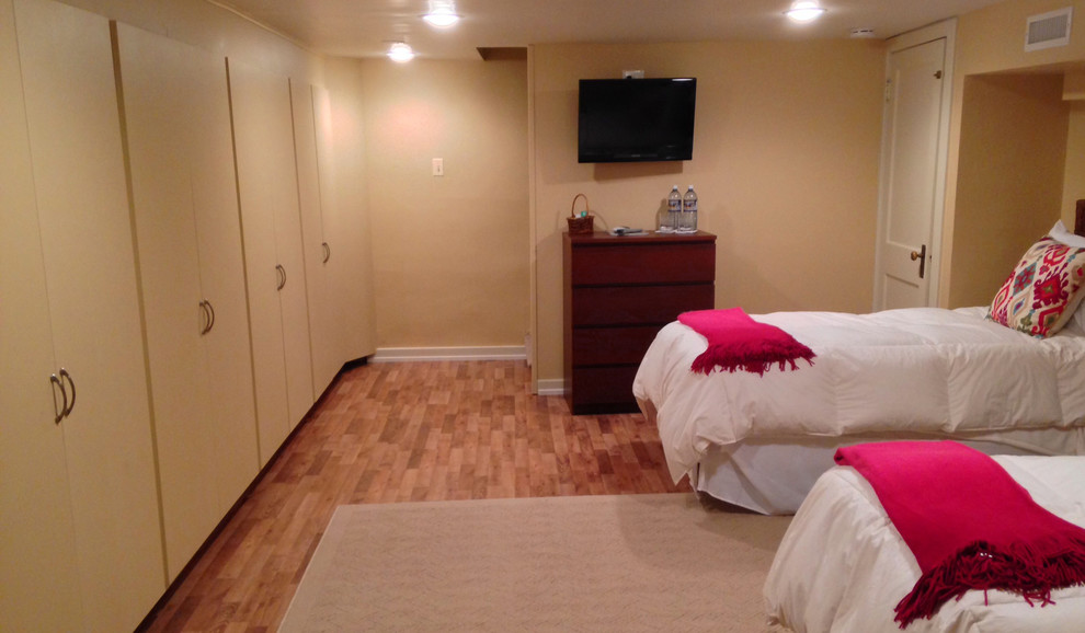 Mid-sized guest medium tone wood floor bedroom photo in Denver with beige walls and no fireplace