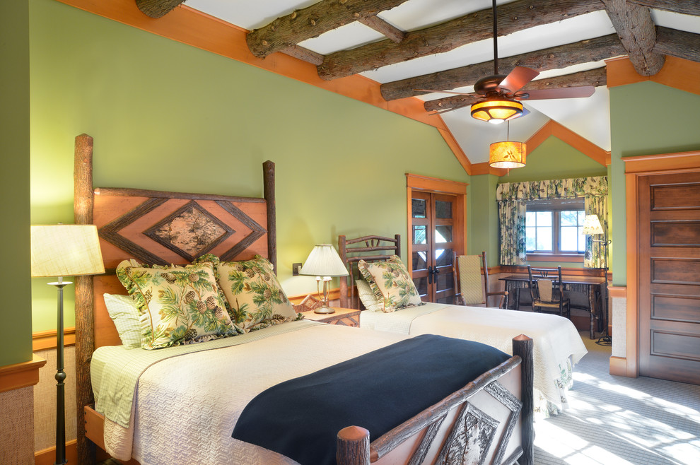 Immagine di una camera da letto rustica con pareti verdi e moquette
