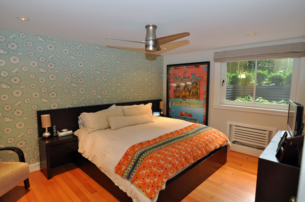 Design ideas for an eclectic bedroom in Seattle with blue walls, medium hardwood flooring and orange floors.