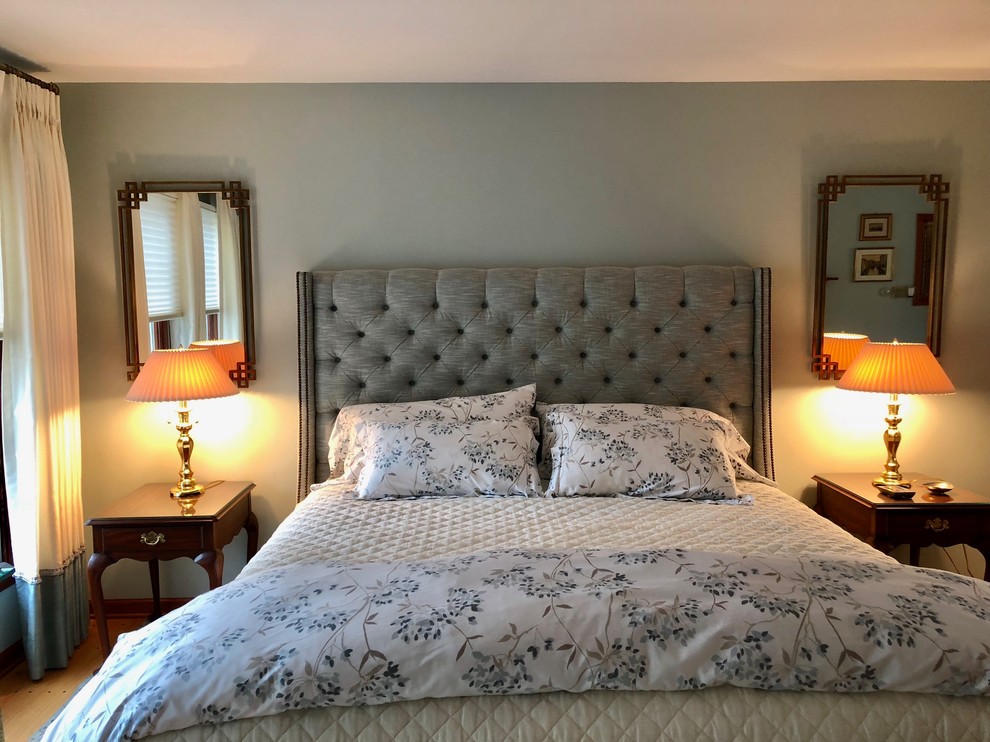 ニューヨークにある小さなコンテンポラリースタイルのおしゃれな主寝室 (青い壁、無垢フローリング、標準型暖炉、レンガの暖炉まわり、茶色い床)